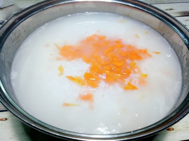 Cho cà rốt vào nồi đun cùng gạo đến khi nhừ thì nêm nếm các gia vị cho đậm đà. 