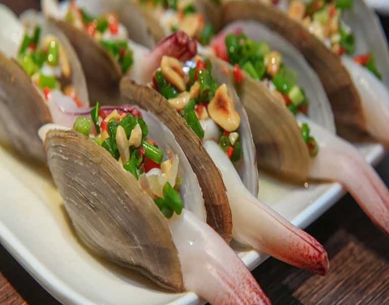 Tu hài nướng mỡ hành là sự kết hợp hoàn hảo giữa hương vị ngọt thanh của hải sản và béo ngậy của sốt mỡ hành